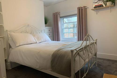 Bett in einem Schlafzimmer mit Fenster in der Unterkunft Grade II listed, town house in Monmouth