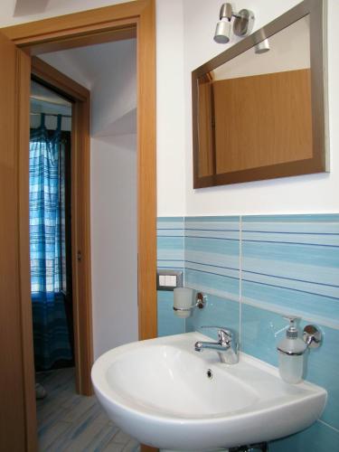 a bathroom with a white sink and a mirror at Dolce Estate Cefalù in Cefalù