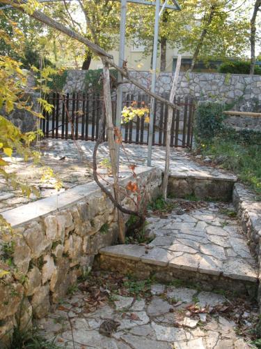 een stenen steunmuur met een trap en een hek bij Villa Maslina in Vantačići
