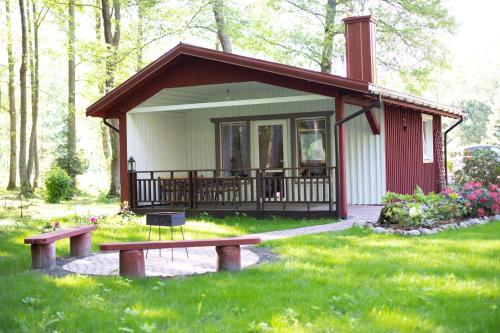 a small cabin with a bench in the grass at Adeles sodyba in Sturmai