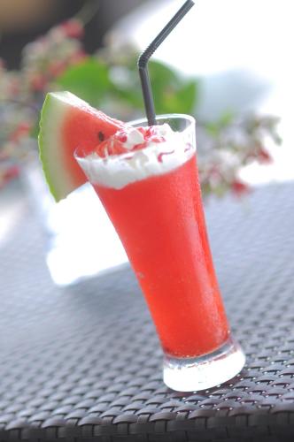 a drink sitting on a table with a slice of watermelon at Lex Hotel Cebu in Cebu City