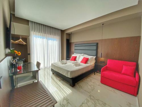 sypialnia z łóżkiem i czerwonym krzesłem w obiekcie B&B BorgiaRooms w mieście Milazzo