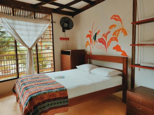 a bedroom with a bed and a clock on the wall at Hostal El Bohío in Palomino
