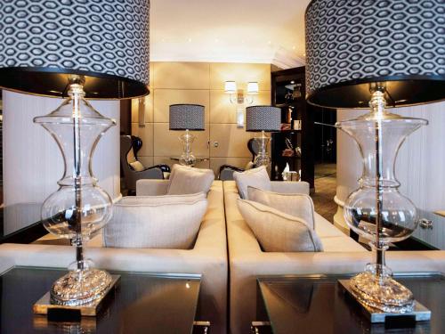 a living room with a couch and two lamps at Park Hôtel Grenoble - MGallery in Grenoble