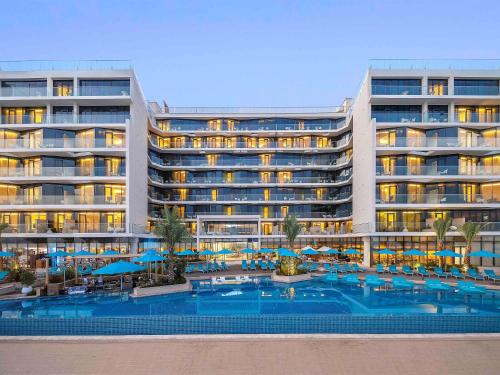 a hotel with a swimming pool and a resort at The Retreat Palm Dubai MGallery by Sofitel in Dubai