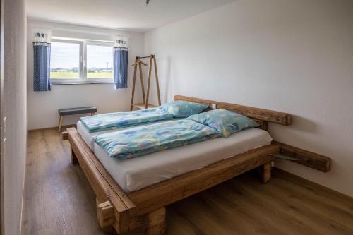 1 dormitorio con cama de madera en una habitación con ventana en Ferienwohnung Häfele 2 en Bad Wurzach