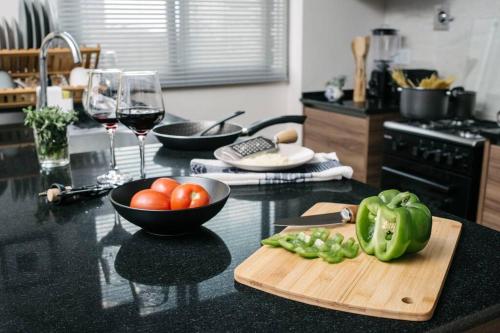 a kitchen counter with a bowl of tomatoes and a cutting board at Apartamento Blue Poet - Sky in Cochabamba