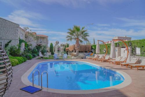 a large swimming pool with lounge chairs and a pool at Alacati Marina Palace in Alacati