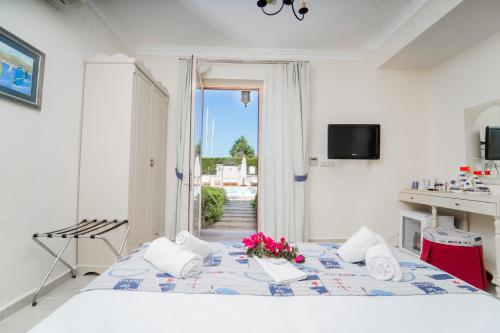 una camera bianca con un letto fiorito di Alacati Marina Palace ad Alaçatı