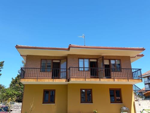 a yellow house with a balcony at Villa La Rufina Noja in Noja