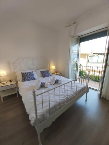 a white bed in a room with a large window at La Guardiola Di Angela e Nino in Taormina