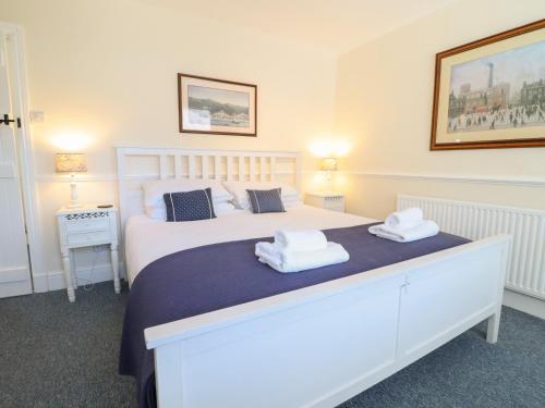 a bedroom with a white bed with towels on it at Sea View apartment in Porthmadog