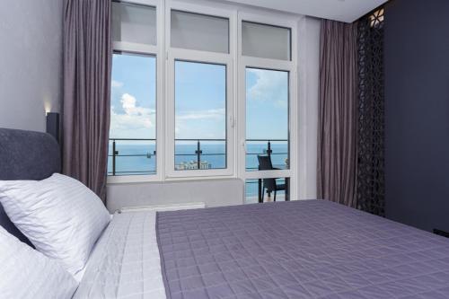 a bedroom with a bed and a large window at Level 24 - Sea & Sky View Apartment in Odesa