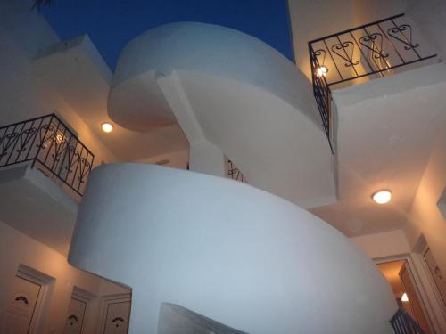 una camera con scala e lampada bianca di Amfi Apartments a Kardámaina