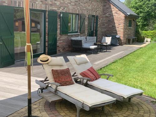 a patio with two lounge chairs and an umbrella at Lovely Meadow House in the land of Croix Scaille in Gedinne