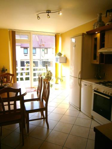 una cucina con tavolo e frigorifero di Apartments Isle of Pinecones a Nida