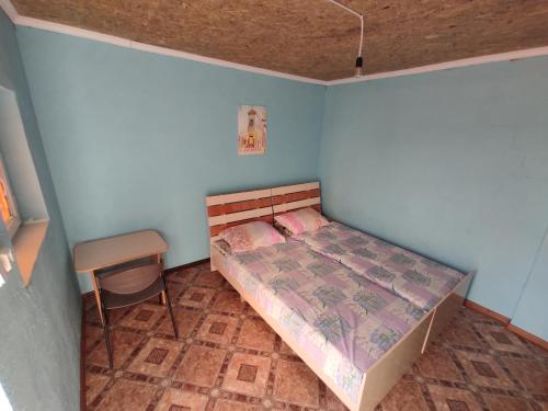 a small bedroom with a bed and a chair at Отдых в Капшагае! in Kapchagay