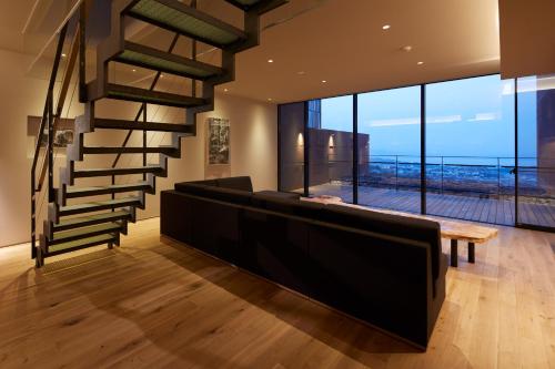 a living room with a spiral staircase and a bench at SEKIYA RESORT Galleria Midobaru in Beppu