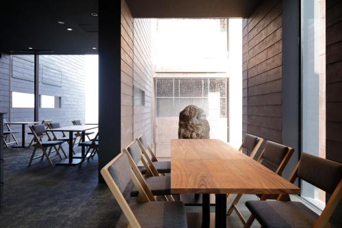 a dining room with a wooden table and chairs at SEKIYA RESORT Galleria Midobaru in Beppu