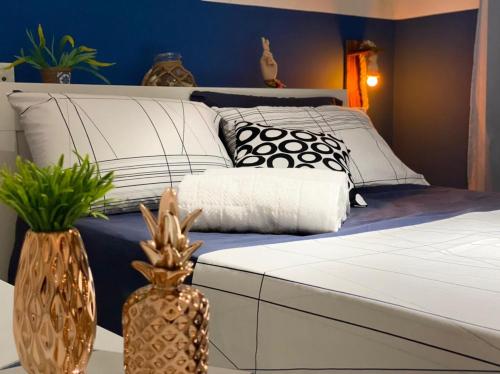 Schlafzimmer mit einem Bett mit weißen und schwarzen Kissen in der Unterkunft Apto Aconchegante em Búzios - Condomínio Talhamar in Búzios