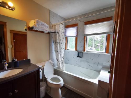a bathroom with a tub and a toilet and a sink at Riverfront Estate Bed&Breakfast Banff in Banff