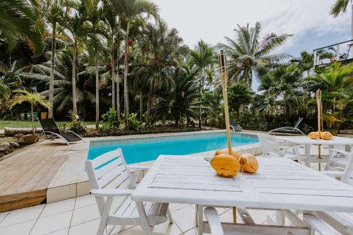 un tavolo bianco con zucche sopra, accanto a una piscina di The Passage Villas a Rarotonga