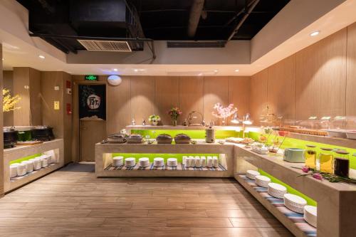 a restaurant with a counter with food on display at Ibis Styles XM Zhongshan Hotel in Xiamen