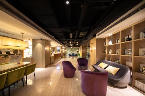 a lobby with chairs and a couch and a bar at Ibis Styles XM Zhongshan Hotel in Xiamen