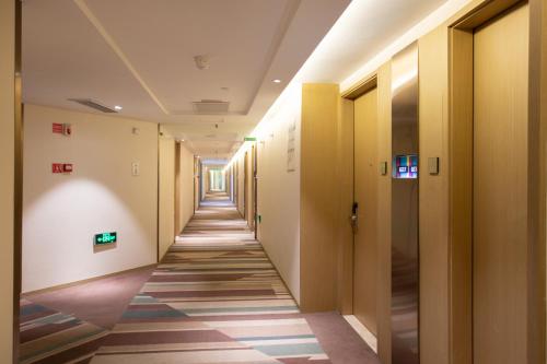 a hallway in a building with a long corridor at Ibis Styles XM Zhongshan Hotel in Xiamen