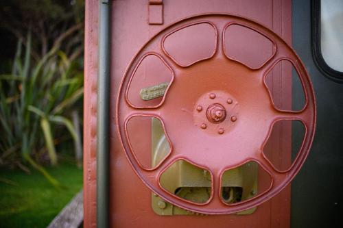 a red door with a circle on it at Solscape in Raglan