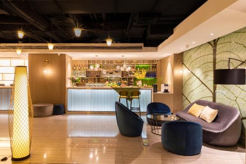 a lobby with chairs and a bar in the background at Ibis Styles XM Zhongshan Hotel in Xiamen