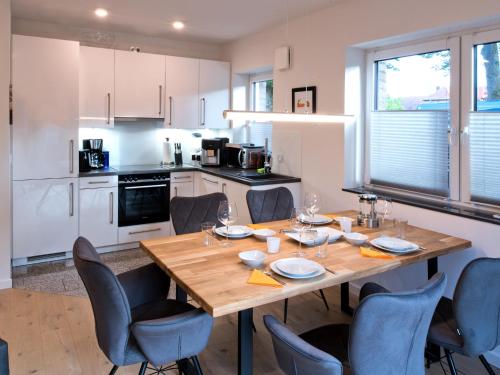 eine Küche mit einem Holztisch und blauen Stühlen in der Unterkunft Landhaus Lueneburg Komfort Apartment in Lüneburg