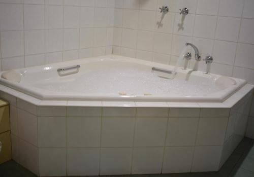 a white bath tub with two faucets on it at Karinya "Peaceful Home" in Bandon Grove
