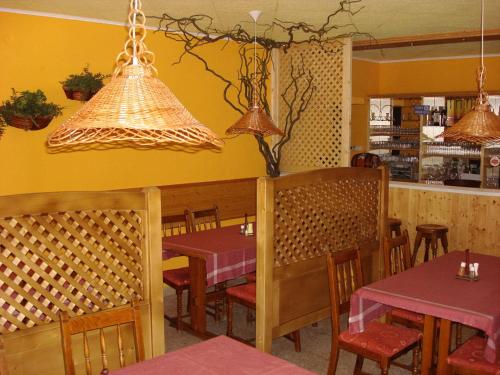 a dining room with tables and chairs and lights at Kis-Duna Motel & Camping in Mosonmagyaróvár