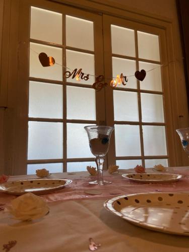 a table with plates and wine glasses and windows at K 357 - Low budget Hotel in Ratekau bei Lübeck in Ratekau