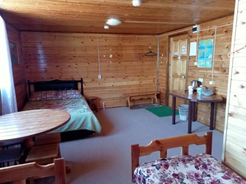 a room with a bed and a table in a cabin at Тимур in Khuzhir