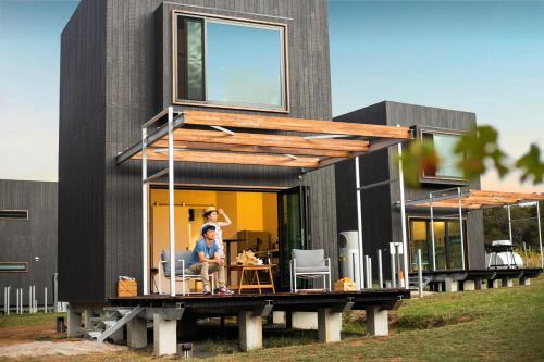 a man sitting at a table in front of a house at Barn Hives Yallingup in Yallingup