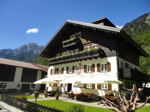 a large white building with a black roof at Walch's Camping & Landhaus in Braz