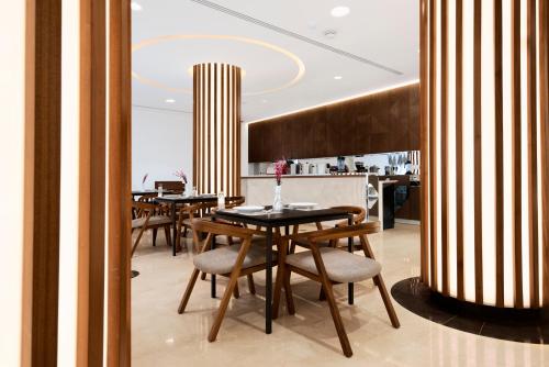 uma sala de jantar com mesas e cadeiras num restaurante em Horizon Hotel em Al Basrah