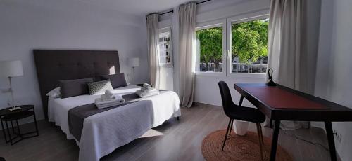 a bedroom with a bed and a desk and a window at Cor de Vinaròs in Vinarós