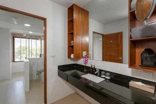 uma casa de banho com um lavatório e um espelho em Sunprime Kamala Beach em Kamala Beach