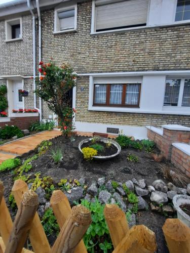 a garden in front of a house with a fence at Maison Chez Lili à 200 m de la plage ,jardin privé et clos in Gravelines