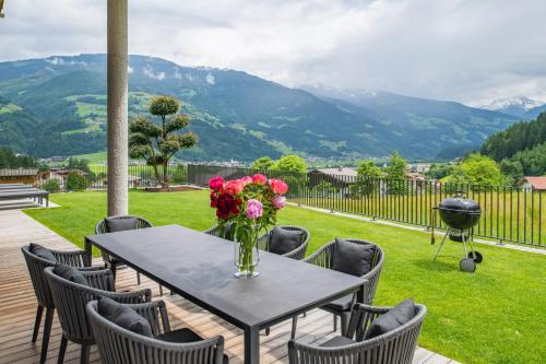 a table with a vase of flowers on a patio at Chalet Isabella in Kaltenbach