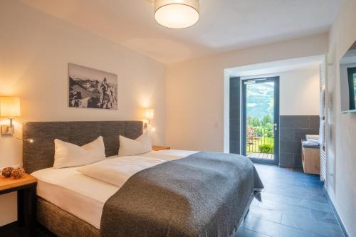 a bedroom with a large bed and a large window at Chalet Isabella in Kaltenbach