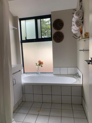 a bathroom with a white tub and a window at Forest Retreat Bed and Breakfast in Margaret River Town