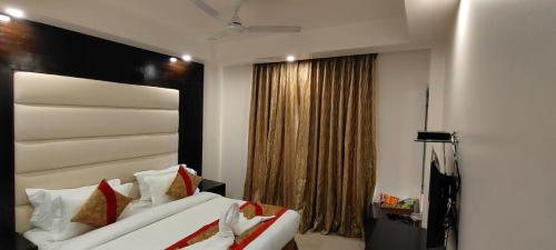 a bedroom with two white beds and a window at Hotel Benz International, Karol Bagh in New Delhi