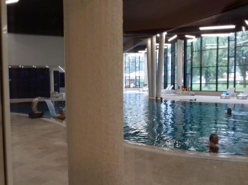a pool in a building with a person in the water at City View Apartment in Fojnica