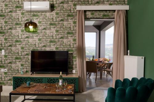 a living room with a television and a green wall at Majestic Villa-Apartments in Darmarochori