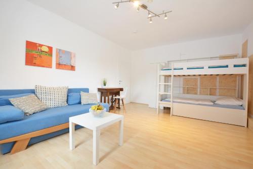 a living room with a blue couch and a bunk bed at Ferienwohnung Alpenblick in Villach