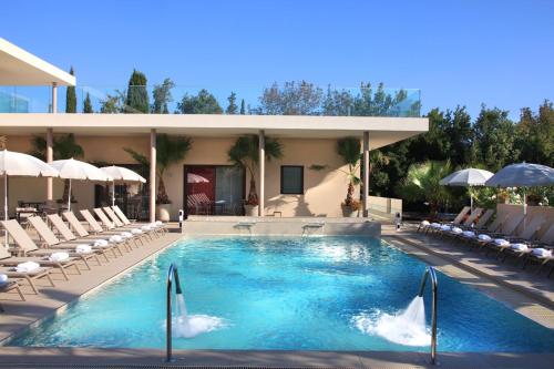 a swimming pool with chairs and a building at Seventeen Hotel in Valbonne